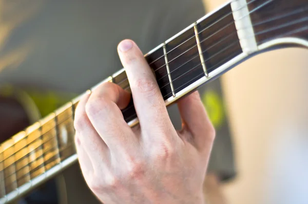 Mão segurando um acorde no pescoço guitarra elétrica . — Fotografia de Stock