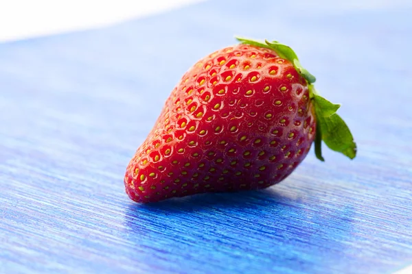 Erdbeeren auf blauem Papier — Stockfoto