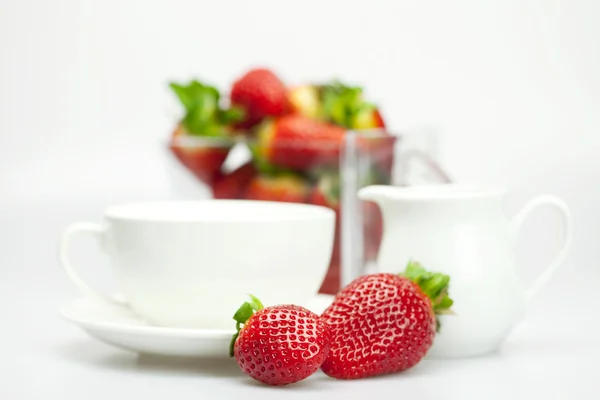 Cup and milk jug with strawberries — Stock Photo, Image