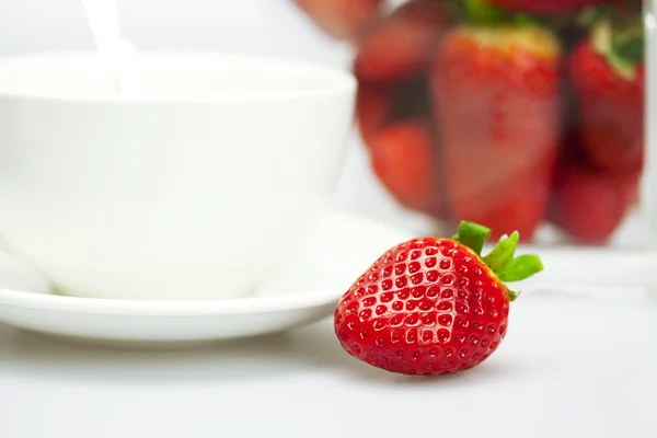 Juicy strawberries and a cup of white isolated on white — Stock Photo, Image