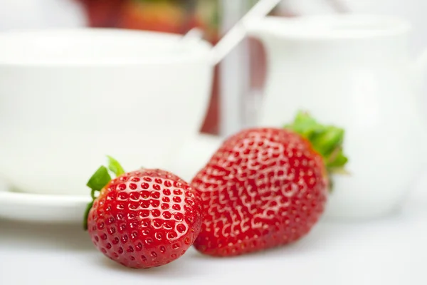 Weiße Tasse und Milchkanne mit Erdbeeren — Stockfoto