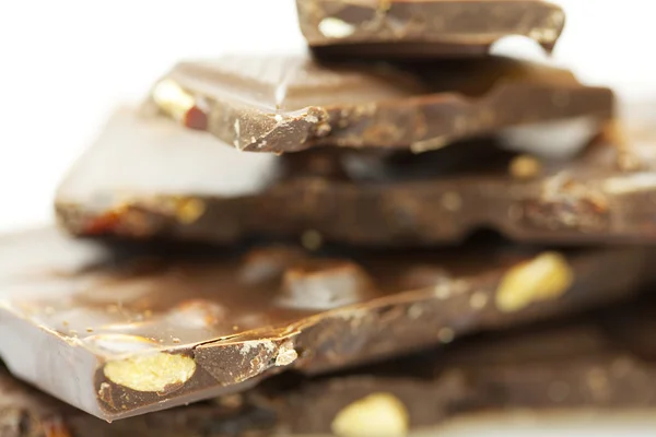 Пачки кусочков шоколада, изолированных на белом — стоковое фото
