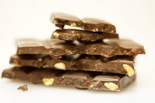 Горные куски шоколада с орехами изолированы на белом — стоковое фото