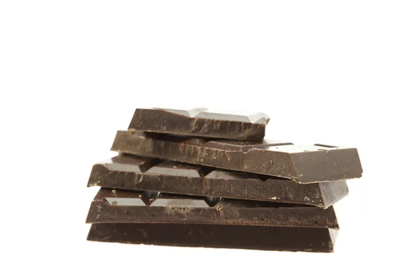 Berg van stukken van chocolade op wit wordt geïsoleerd — Stockfoto