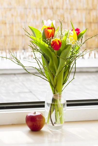 Bouquet di primavera con tulipani e una mela — Foto Stock