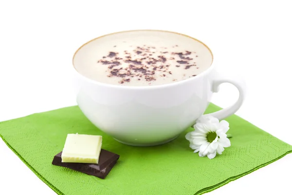Cup of cappuccino, chocolate and flower on a napkin — Stock Photo, Image