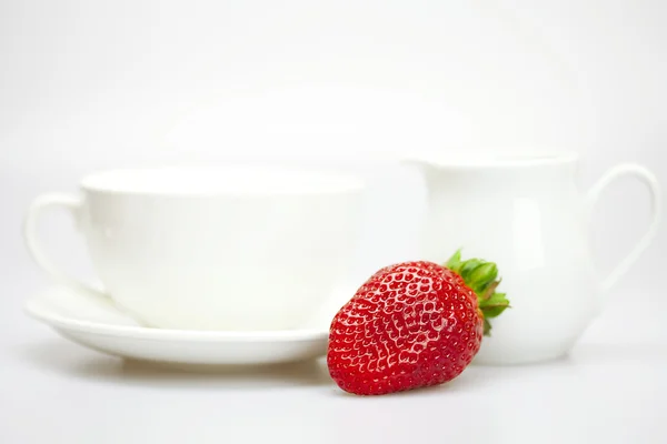 White cup and milk jug with strawberries — Stock Photo, Image