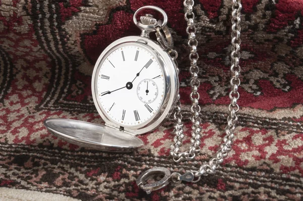 Reloj de bolsillo de plata en la alfombra — Foto de Stock