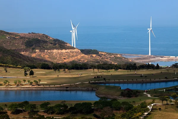 Lugar de golfe com bom verde e moinho de vento poder após o lugar — Fotografia de Stock