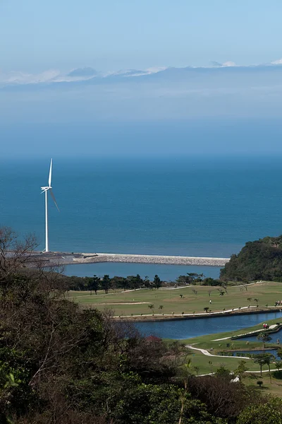 Lugar de golfe com bom verde e moinho de vento poder após o lugar — Fotografia de Stock