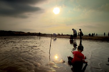 Deniz Günbatımı ile oynayan çocuk ayarla