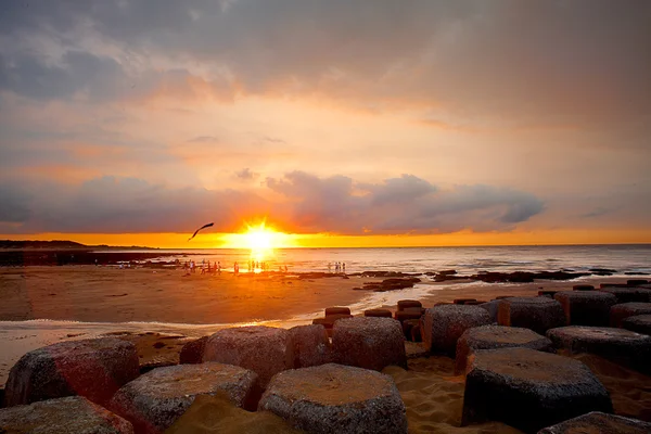 Puesta de sol con piedra junto al mar — Foto de Stock