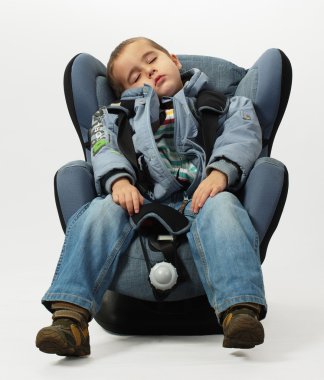 Boy sleeps in safe auto chair clipart