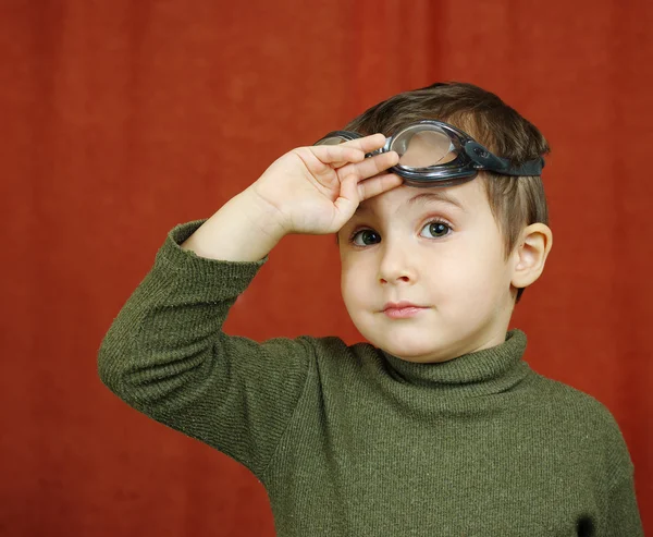 Маленький мальчик в очках играет пилота — стоковое фото