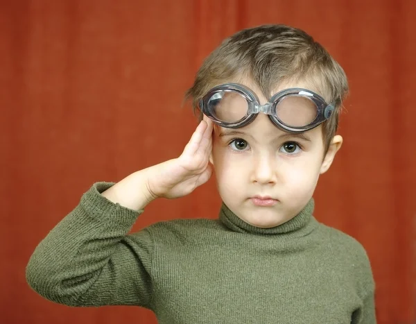 Kleine jongen in zwemmen bril speelt een piloot — Stockfoto