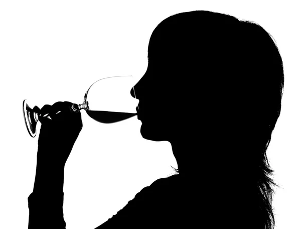 Silhueta da mulher que bebe o vinho tinto — Fotografia de Stock