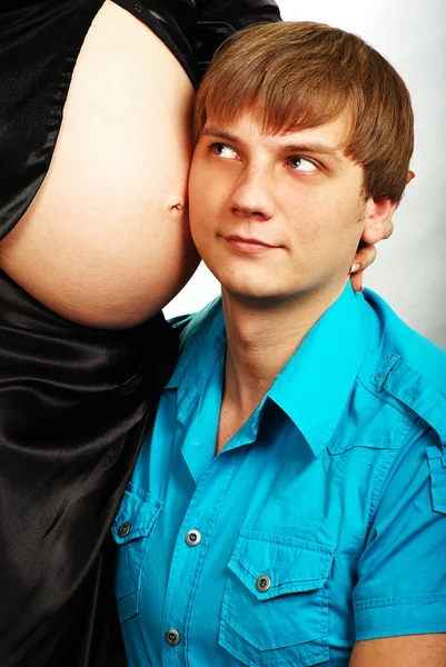 Father listens to his child in mothers belly — Stock Photo, Image