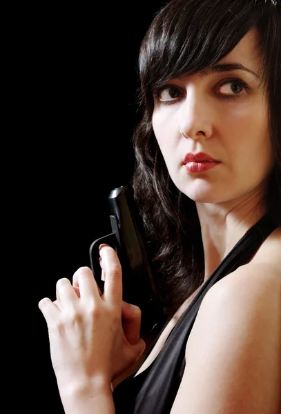 Vrouw in avondjurk houdt pistool — Stockfoto