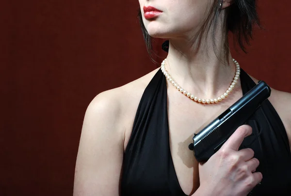 Beautiful woman in evening dress with gun — Stock Photo, Image