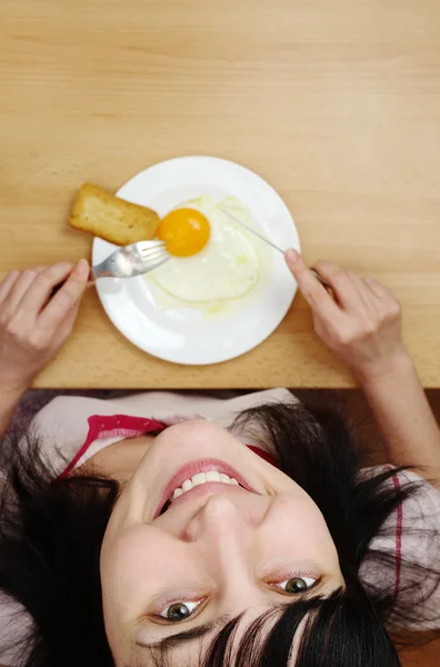 Красивая женщина ест солнечное яйцо — стоковое фото