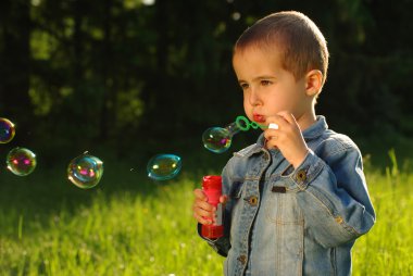 Little boy makes bubbles clipart