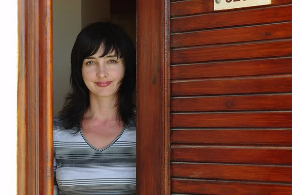 Schöne Frau begrüßt an der Tür — Stockfoto