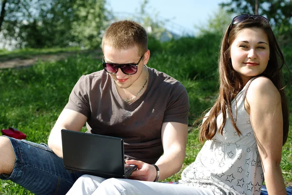 Νεαρό ζευγάρι με το laptop στο πάρκο — Φωτογραφία Αρχείου