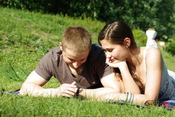 在绿色草地上放松对年轻夫妇 — 图库照片