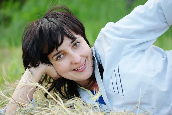 干し草の上に横たわる遊び心のある女性 — ストック写真