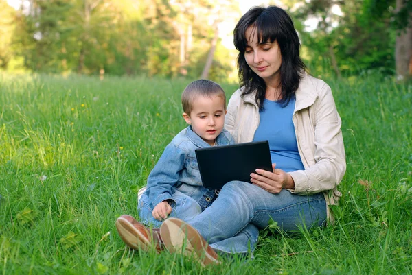 Mãe e filho com laptop ao ar livre — Fotografia de Stock