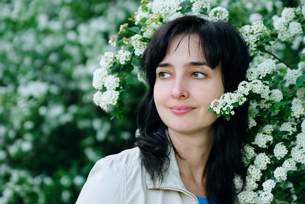 Schöne Frau in blühenden Blumen — Stockfoto