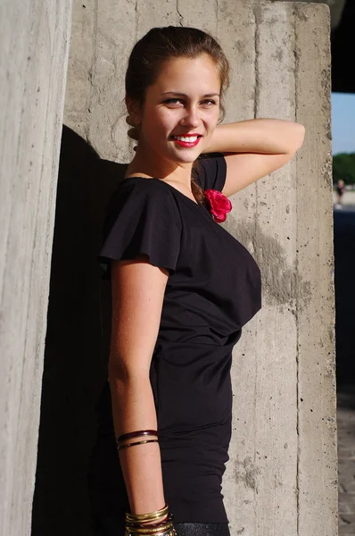 Jovem bela mulher magra pela parede de concreto — Fotografia de Stock