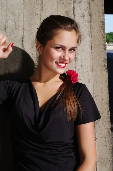 Mujer joven hermosa magra por el muro de hormigón — Stockfoto