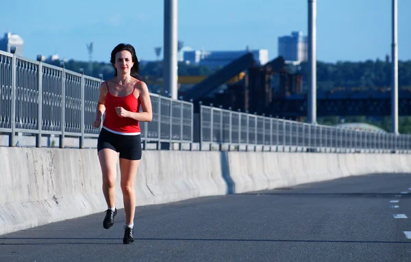 Vrouw joggen op de snelweg — Stockfoto