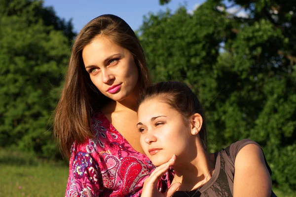 Dos chicas inclinadas en la luz del atardecer al aire libre —  Fotos de Stock