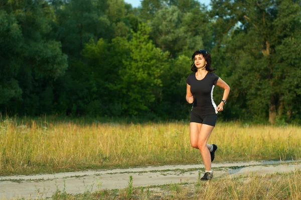 Žena běhání venku v lese — Stock fotografie