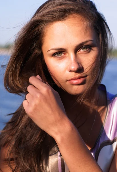 Hermosa chica con el pelo largo en la orilla del río —  Fotos de Stock