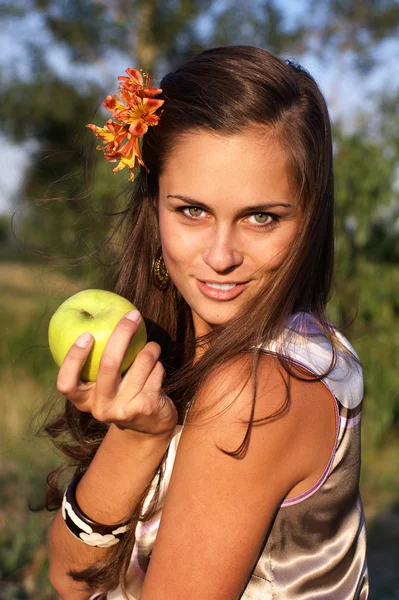Mulher com maçã com flor no cabelo — Fotografia de Stock