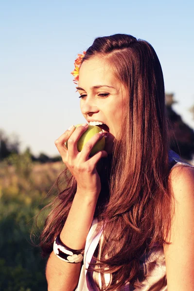 Menina jovem morder maçã — Fotografia de Stock