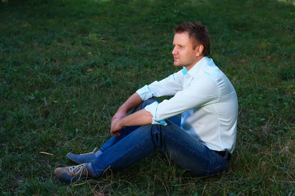 stock image Young man sitting on the grass