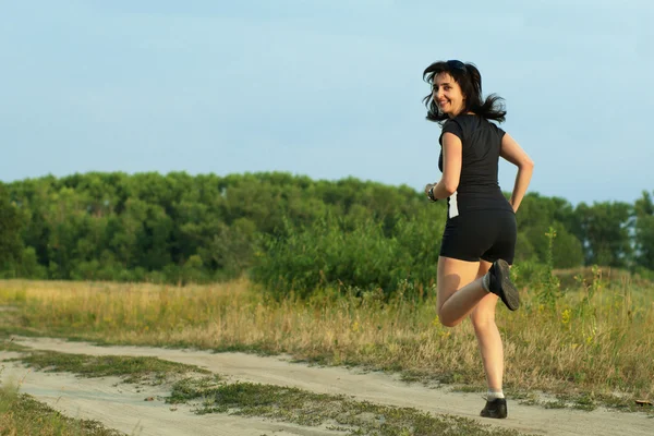 Vrouw joggen buiten omdraaien — Stockfoto
