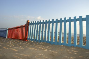 kleine blauwe en rode hek op het strand