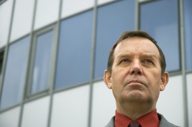 Businessman in front of a office building clipart