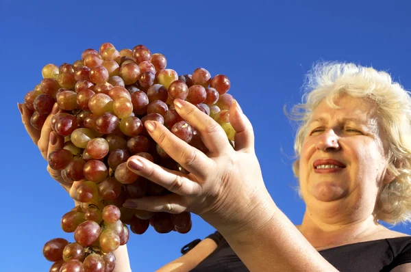 Зрелая женщина и виноград — стоковое фото