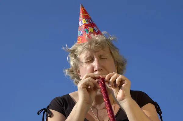 Woman with noisemaker on the party — Stock Photo, Image