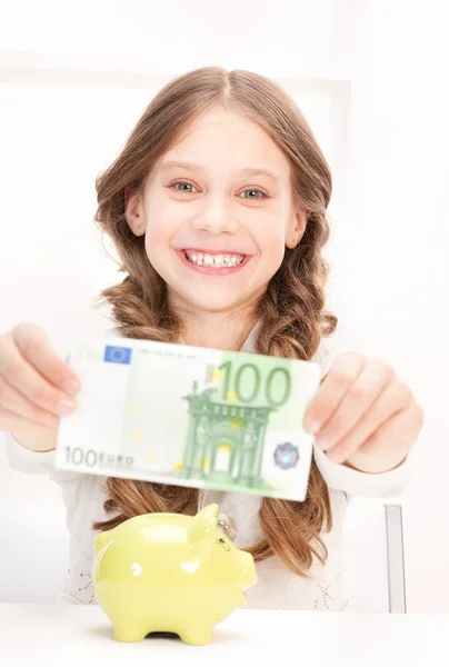 Dziewczynka z piggy bank i pieniądze — Zdjęcie stockowe