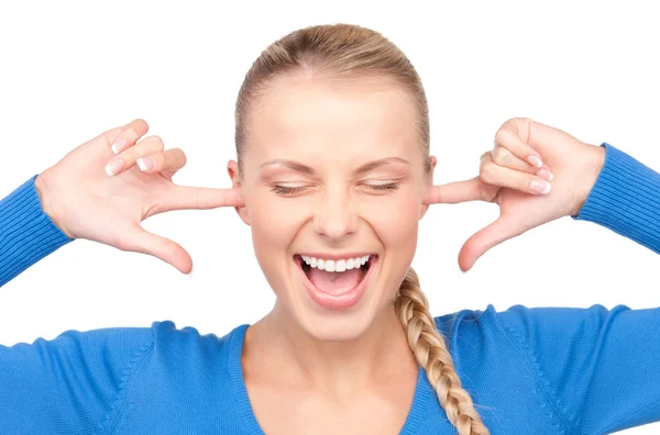 Smiling woman with fingers in ears — Stockfoto