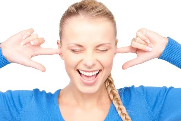 Femme souriante avec les doigts dans les oreilles Image En Vente