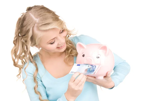 Schöne Frau mit Sparschwein und Geld — Stockfoto