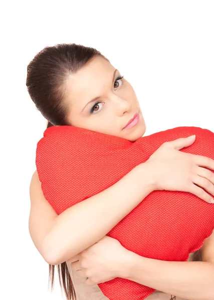 Kvinna med röd hjärtformad kudde över vita — Stockfoto